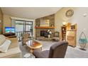 Bright living room with a stone fireplace, carpet, and a balcony offers a cozy space at 7780 W 87Th Dr # E, Arvada, CO 80005
