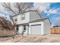 View of home with gray siding, a one-car garage, xeriscaped front yard, and driveway at 1277 W 135Th Pl, Broomfield, CO 80234