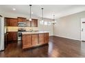 Well-equipped kitchen with dark wood cabinets, stainless steel appliances, and a spacious center island with pendant lighting at 21646 E Stroll Ave, Parker, CO 80138