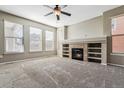 Bright living room with a cozy fireplace, built-in shelves, and large windows that bring in abundant natural light at 21646 E Stroll Ave, Parker, CO 80138