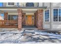 Brick columns and wooden front door leading to the entrance of the home at 7212 S Acoma St, Littleton, CO 80120