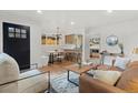 Bright living room with hardwood floors, modern furnishings, and a view into the updated kitchen at 3377 N Krameria St, Denver, CO 80207