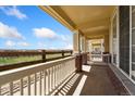 Inviting covered porch featuring classic columns and brick accents, perfect for enjoying the outdoor scenery at 16212 E Geddes Ln # 11, Aurora, CO 80016
