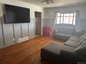 Casual living room with hardwood floors, a gray sofa, and natural light from the window at 7488 Quivas St, Denver, CO 80221