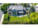 Expansive backyard featuring a lush lawn, mature trees, patio area, and elegant exterior design at 10293 E Sheri Ln, Englewood, CO 80111
