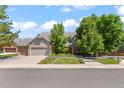 Beautiful two-story home with a well-manicured lawn, mature trees, and a three-car garage at 10293 E Sheri Ln, Englewood, CO 80111