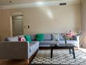 Comfortable living room with gray sectional sofa, patterned rug, and large window offering ample natural light at 1659 Harris St, Superior, CO 80027