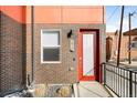 Close-up of modern brick building entryway with vibrant red door, and visible unit number at 1912 W 38Th Ave, Denver, CO 80211