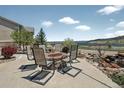 Enjoy outdoor living with patio seating by a stone fire pit and water feature with beautiful landscape views at 3255 Waterfront Dr, Monument, CO 80132