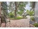 Stone patio with seating providing serene outdoor living space surrounded by lush greenery and mature trees at 8216 S Krameria Way, Centennial, CO 80112