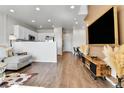 Bright open-concept living area with hardwood floors, modern decor, and a view of the kitchen at 6459 N Dunkirk St, Denver, CO 80249