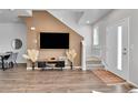 Inviting living area with hardwood floors, staircase, and natural light from the entry door at 6459 N Dunkirk St, Denver, CO 80249
