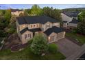 Aerial view of a two-story home with manicured lawn and mature trees at 10524 Serengeti Dr, Lone Tree, CO 80124