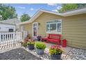 Charming single-story home with a cozy front porch and well-manicured garden featuring vibrant potted flowers at 1817 S Perry Way, Denver, CO 80219