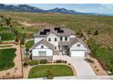 Breathtaking aerial view of a solar paneled two-story home nestled against a backdrop of mountains and lush greenery at 9571 Yucca Ct, Arvada, CO 80007