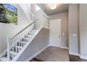 Bright foyer with a staircase featuring white railings, leading to upper level, and an art on the wall at 9571 Yucca Ct, Arvada, CO 80007