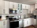 Bright kitchen featuring stainless steel appliances, white cabinets, and modern backsplash at 2200 W Moffat Pl, Denver, CO 80221