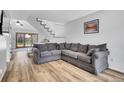Comfortable living room with large grey sofa, hardwood floors, and stairs leading to the second floor at 655 Gooseberry Ct, Lafayette, CO 80026
