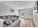Comfortable living room with a large sectional sofa, wood flooring, and natural light at 655 Gooseberry Ct, Lafayette, CO 80026
