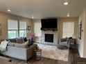 Living room featuring a modern fireplace, large windows, neutral color palette and plush seating at 12901 Crane River Dr, Longmont, CO 80504