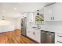Updated kitchen with stainless steel appliances, white cabinets, and hardwood floors at 2280 Sherrelwood Dr, Denver, CO 80221