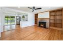 Spacious living room featuring a fireplace, built-in bookshelves, and hardwood floors at 2280 Sherrelwood Dr, Denver, CO 80221