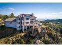 Hillside home features a grey exterior, large windows, and wood decks perfect for relaxing at 14440 Eagle Vista Dr, Littleton, CO 80127