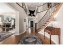 Grand entryway with hardwood floors, curved staircase, and views into the living room at 42280 Kingsmill Cir, Elizabeth, CO 80107