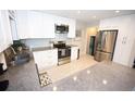 Well-lit kitchen featuring granite countertops, stainless steel appliances, and white cabinets at 3111 W Bails Pl, Denver, CO 80219