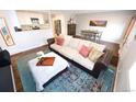 Open living space with a large sofa, stylish rug, and adjacent dining area at 3111 W Bails Pl, Denver, CO 80219