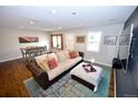 Cozy living area with hardwood floors, stylish rug, and comfortable sofa at 3111 W Bails Pl, Denver, CO 80219