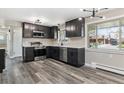 A well-lit kitchen features stainless steel appliances, granite countertops and hardwood floors at 6913 Teller Ct, Arvada, CO 80003