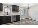 Modern kitchen featuring stainless steel appliances, dark cabinets, white countertops and hardwood flooring at 6913 Teller Ct, Arvada, CO 80003
