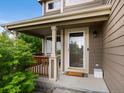 Covered front porch featuring wood columns, neutral siding, and storm door with a full view glass panel at 23222 E Orchard Pl, Aurora, CO 80015