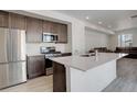Eat-in kitchen features stainless steel appliances, a breakfast bar, and flows into the living space at 24501 E 41St Ave, Aurora, CO 80019