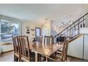 Formal dining room with wood floors, a staircase and a view into the kitchen at 4783 S Taft St, Morrison, CO 80465