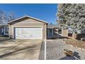 A single-story home featuring a well-maintained front yard, two-car garage and a quaint entrance at 4783 S Taft St, Morrison, CO 80465