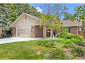 Well-maintained front yard with healthy grass, flowering plants, and a large tree at 37 E 14Th Pl, Broomfield, CO 80020