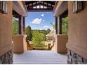 Inviting porch showcasing stunning mountain views, neutral wood beams, stone accents, and a lovely wood floor at 722 Evening Star Dr, Castle Rock, CO 80108