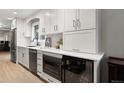 Stylish kitchen featuring white cabinets, a stainless steel dishwasher, a wine cooler, and a microwave at 6341 E Floyd Dr, Denver, CO 80222