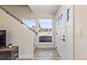 Bright entryway features modern staircase, large windows, and a white front door at 2253 Kipling St, Lakewood, CO 80215