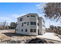 Rear view of a modern white townhome showcasing geometric windows and a concrete patio at 2253 Kipling St, Lakewood, CO 80215
