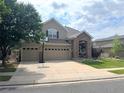 Two-story home featuring a stone entrance, a three-car garage, and a driveway and lawn at 14096 Roaring Fork Cir, Broomfield, CO 80023