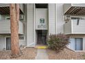 Exterior view of the building entrance with unit number signage, shrubbery, and concrete walkway at 10150 E Virginia Ave # 7-304, Denver, CO 80247