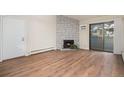 Open-concept living room with a decorative stone fireplace, wood floors, and sliding glass doors at 10150 E Virginia Ave # 7-304, Denver, CO 80247