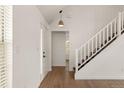 Bright foyer featuring a white staircase, wood floors, and a view into other rooms of the home at 11519 Wray Ct, Parker, CO 80134