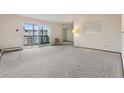 Spacious living room featuring neutral carpeting and a sliding glass door to the balcony at 9625 E Center Ave # 5C, Denver, CO 80247