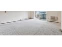 Bright living room with carpet, opening to a balcony with abundant natural light at 9625 E Center Ave # 5C, Denver, CO 80247
