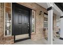 Close-up of the front door showcasing the brick facade and covered porch with seating at 20650 Parker Vista Cir, Parker, CO 80138