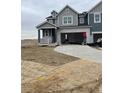 New construction home boasts a stylish exterior with grey and white brick accents, and attached two-car garage at 6709 Juniper Dr, Thornton, CO 80602